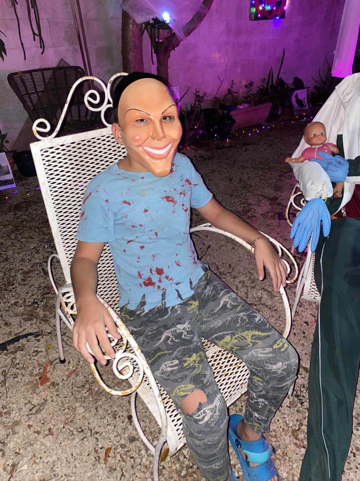 Alex, el pequeño enmascarado de los anfitriones de 2025, espera sentado entre la decoración de Halloween