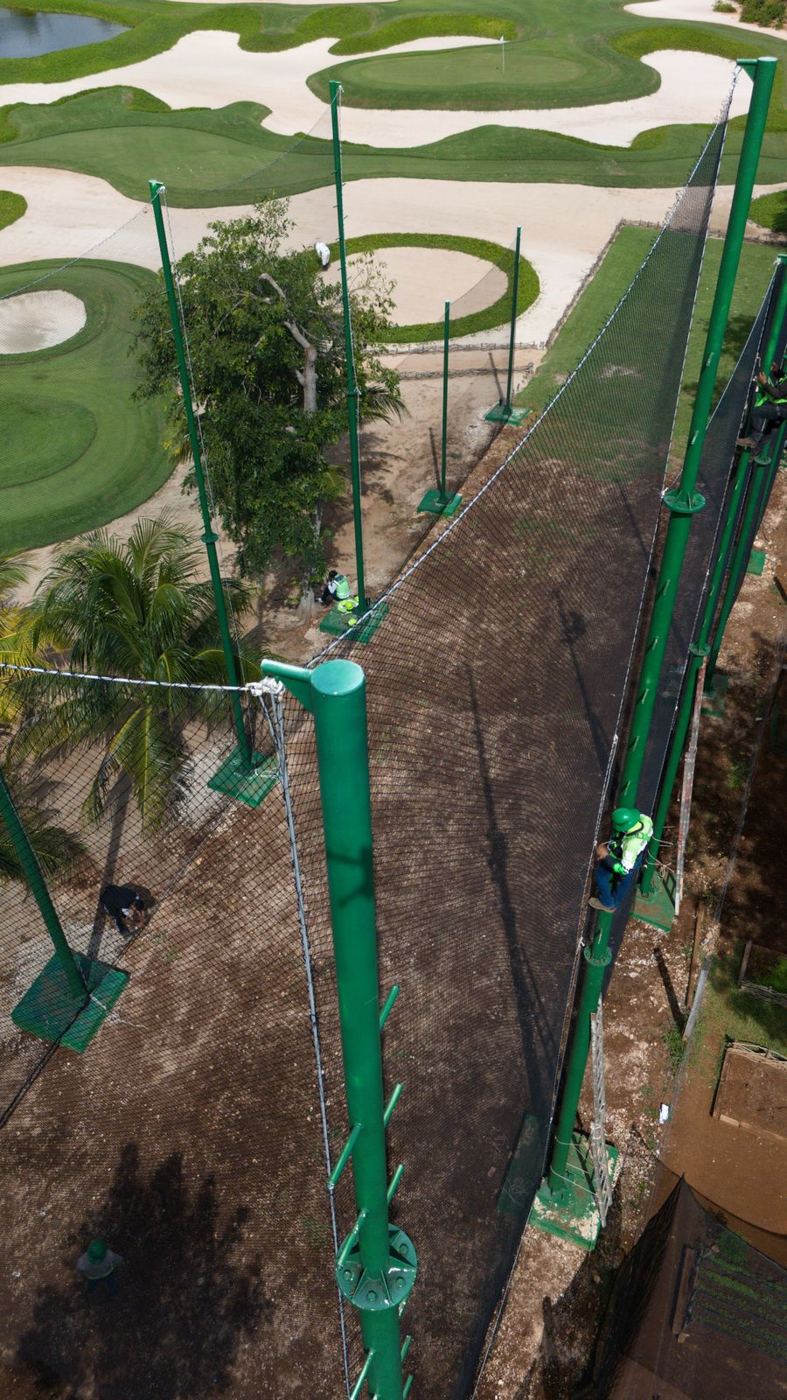 Instalación de red de contención para golf con postes verdes en el Hotel Chablé