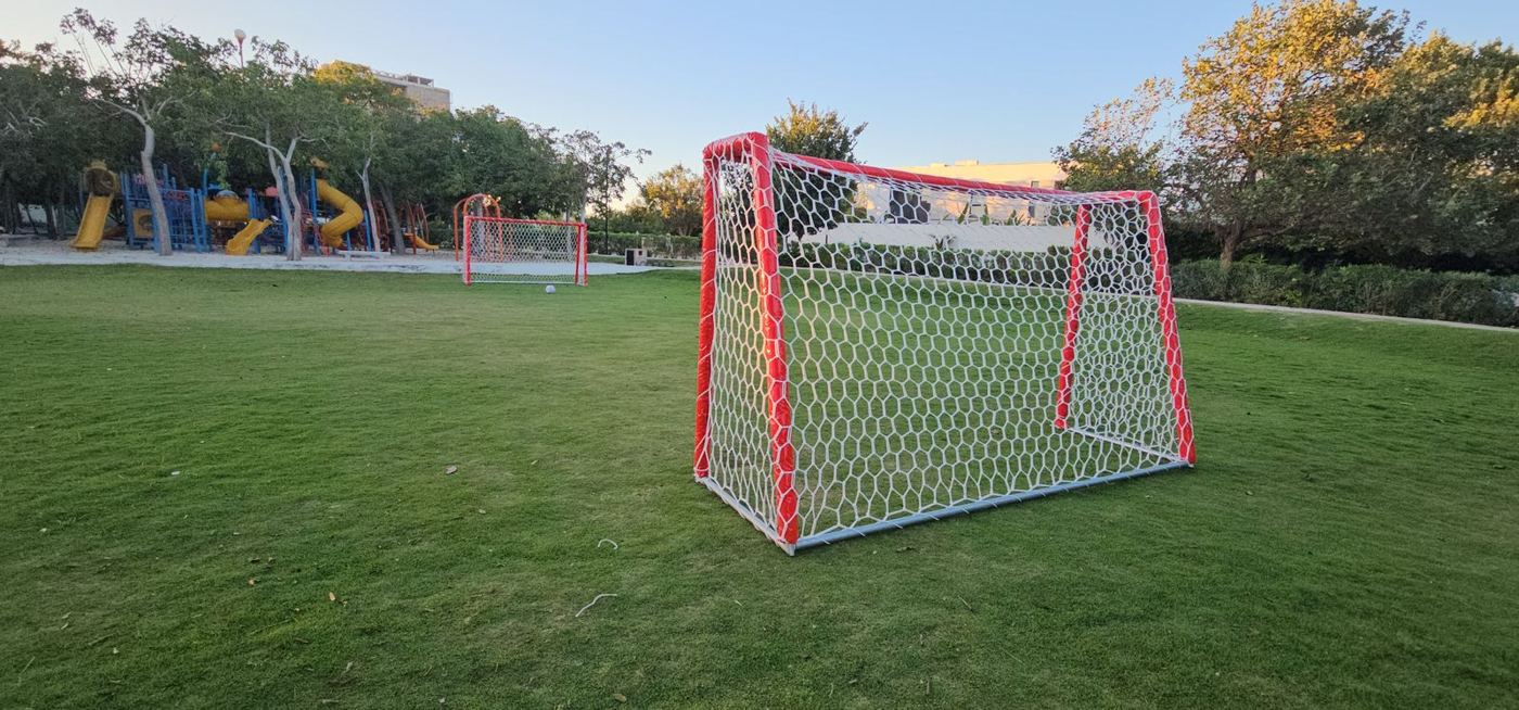 Portería de fútbol forrada en rojo con red hexagonal blanca tipo colmena