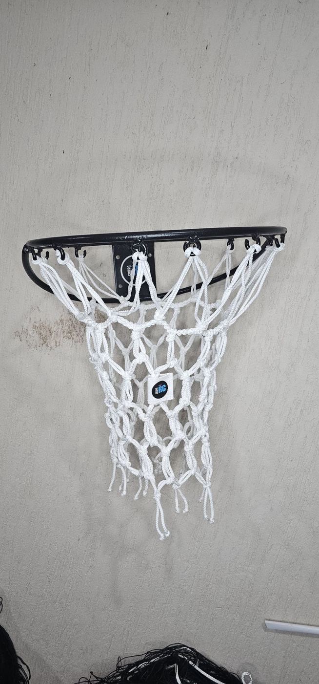 Red de básquetbol blanca trenzada colocada en un aro negro