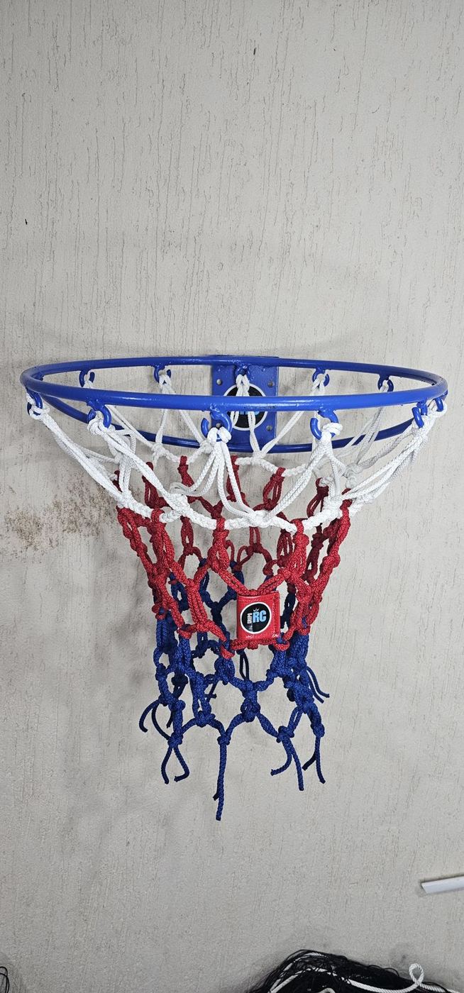 Red de básquetbol trenzada tricolor blanca, roja y azul colocada en el aro