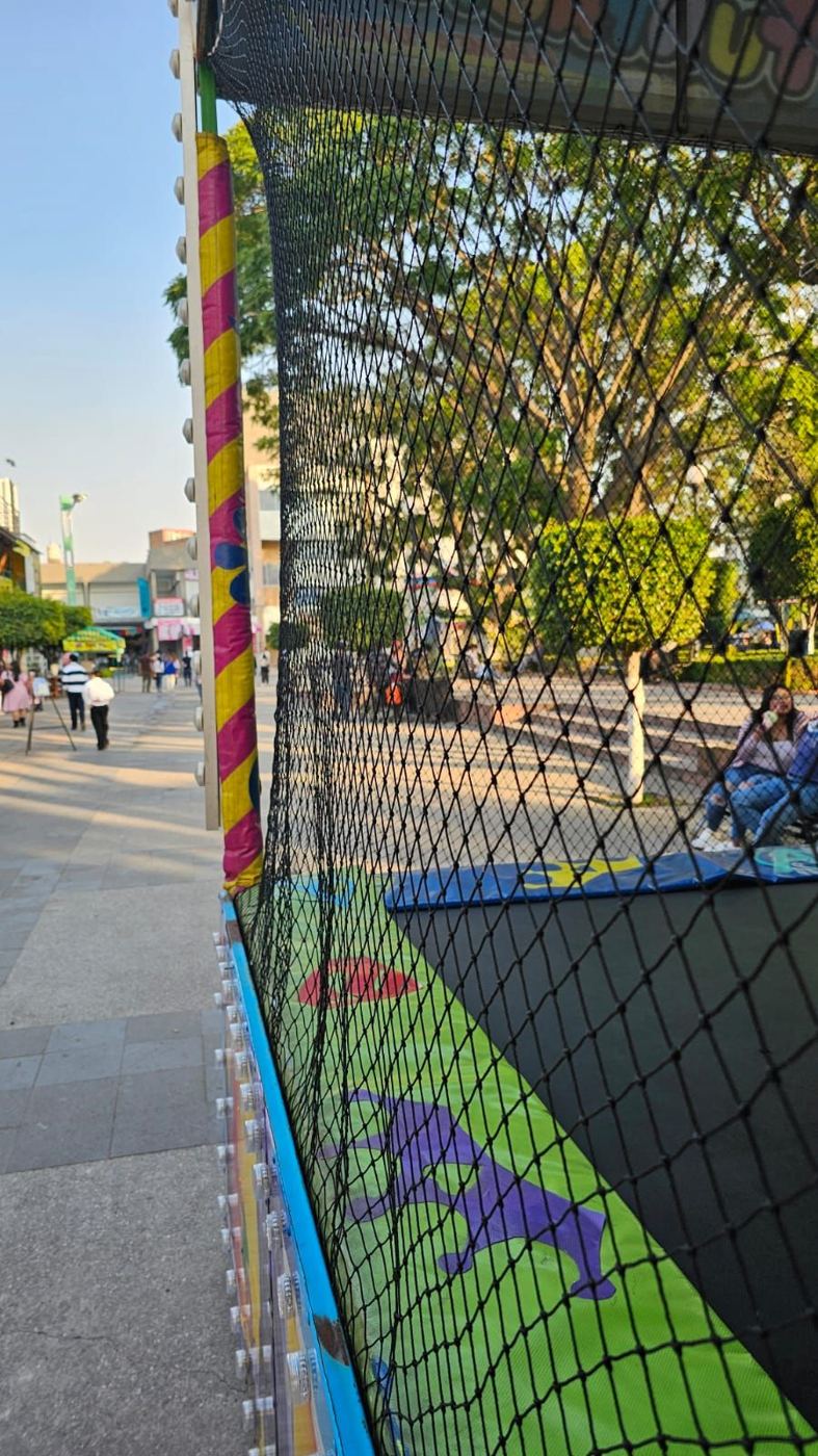 Red de protección negra con postes forrados en un área de juegos