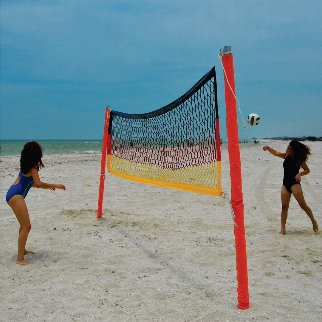 Red de voleibol de playa con postes forrados en rojo instalada en la arena