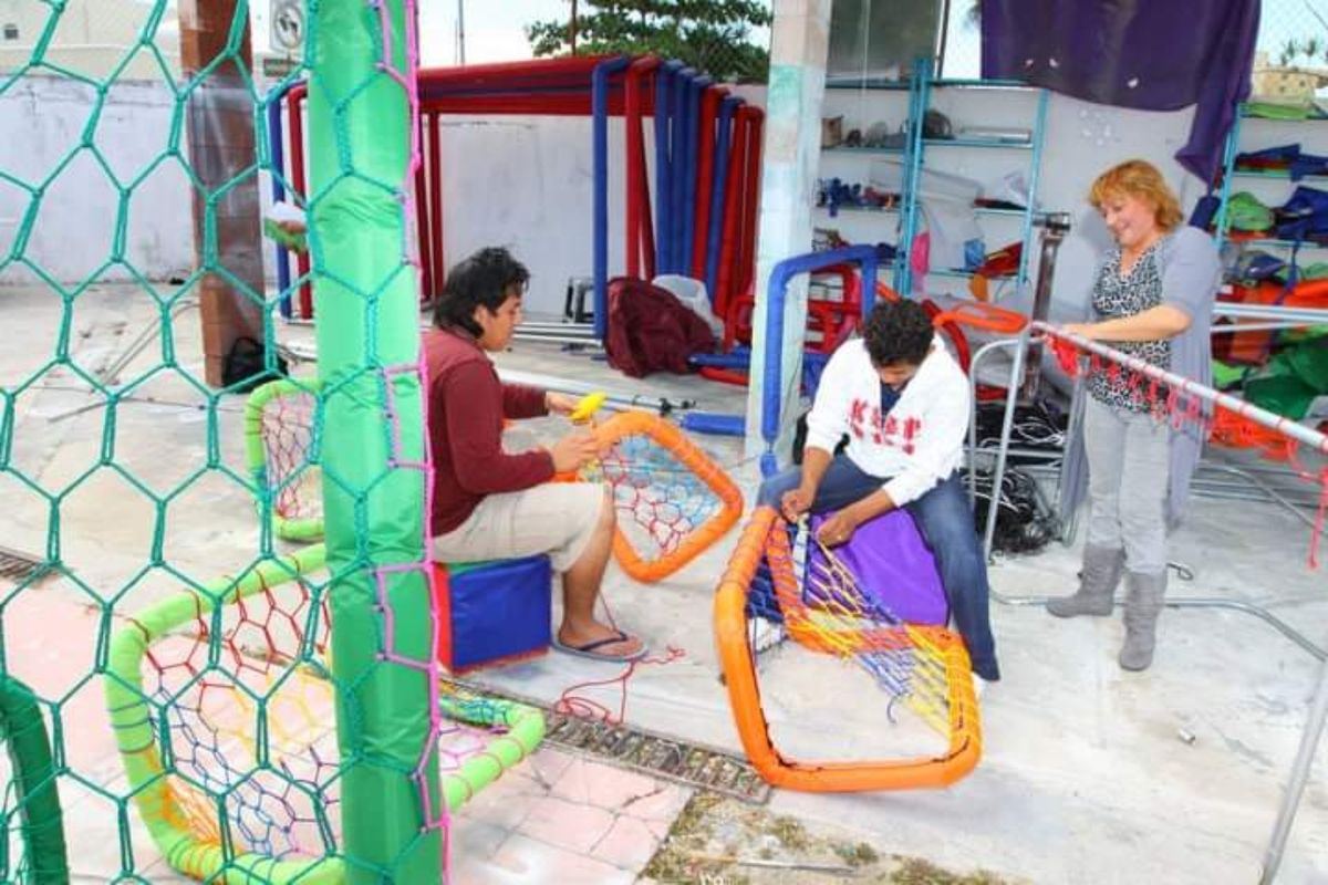 Taller familiar tejiendo a mano redes deportivas sobre porterías de colores